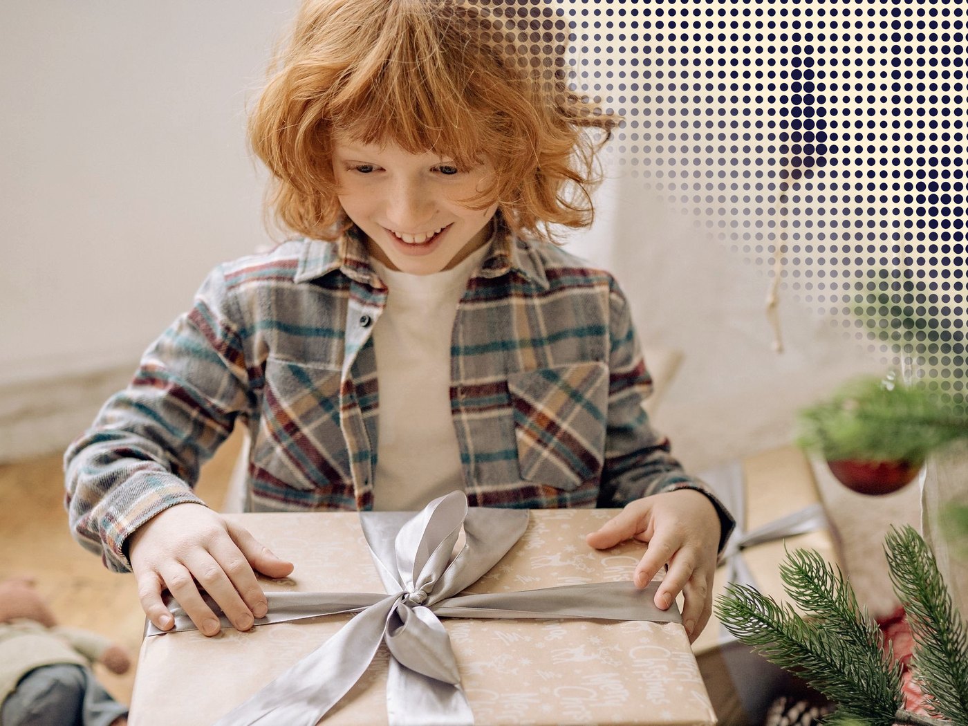 Niño sonriendo al abrir un regalo