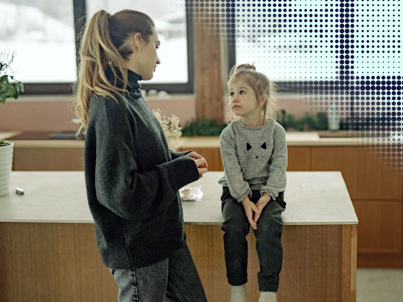 Madre conversando con su hija pequeña en la cocina