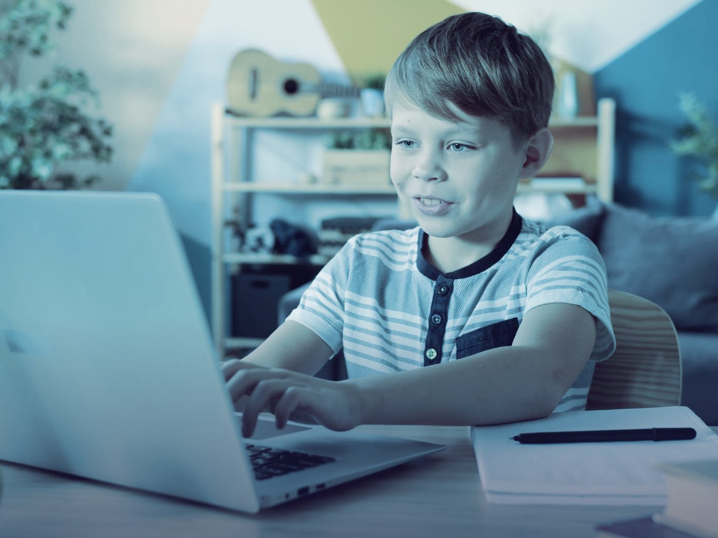 Niño sonriendo mientras usa su computador