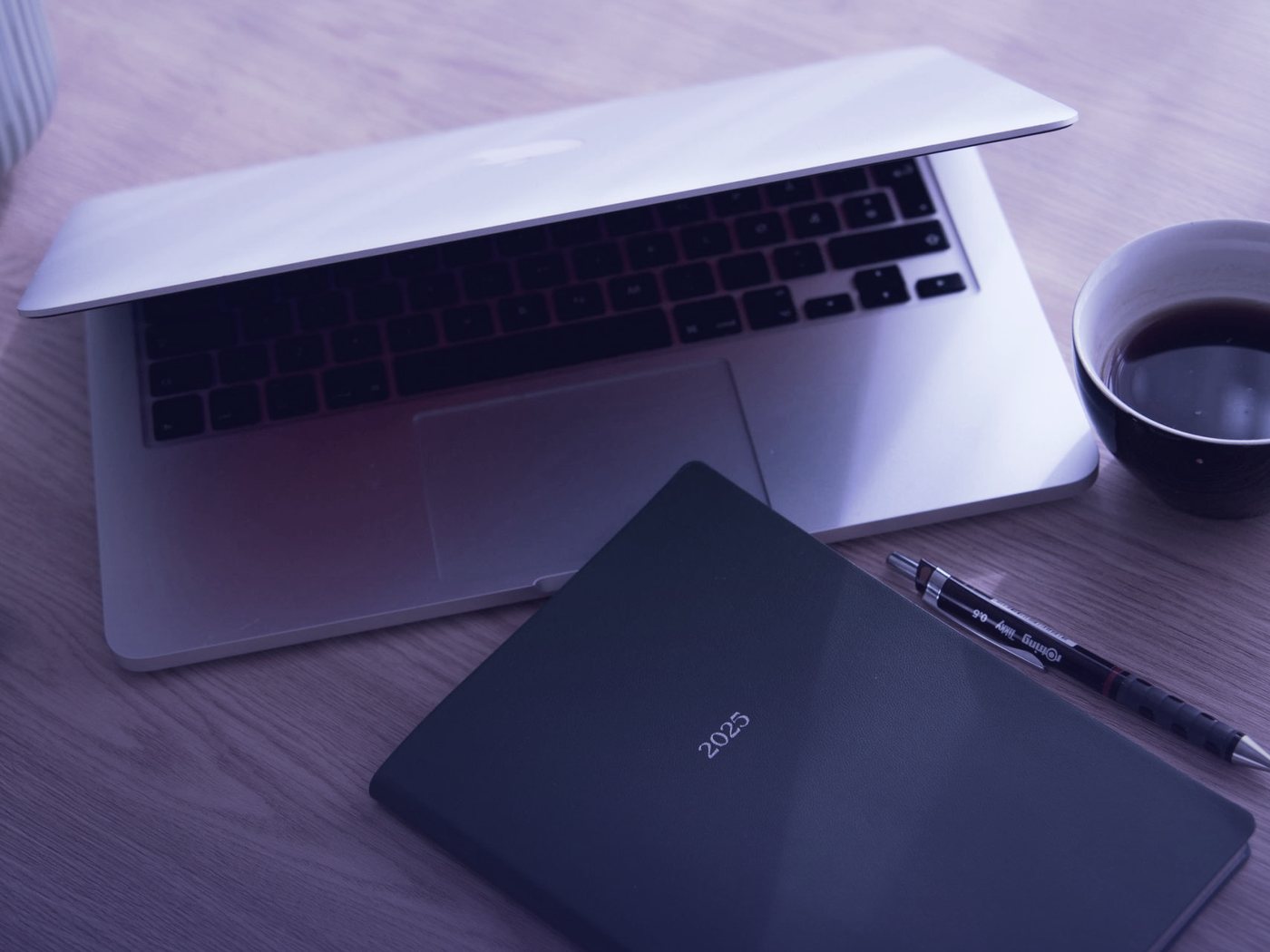 Escritorio ordenado con computador, cuaderno y café