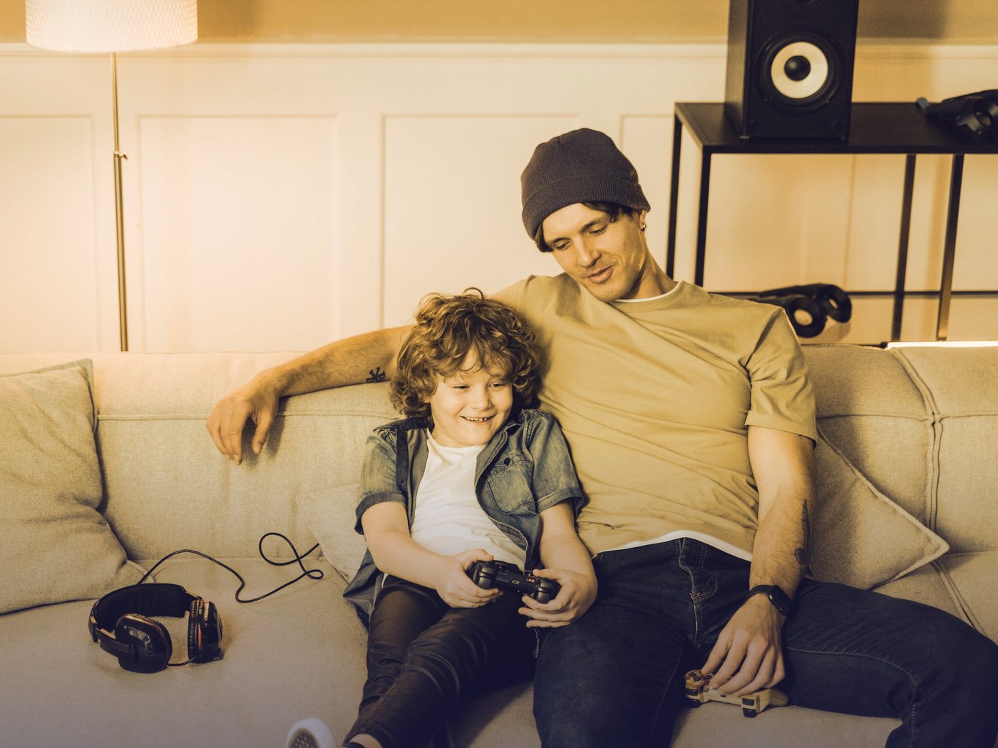 Padre e hijo jugando videojuegos en el sillón
