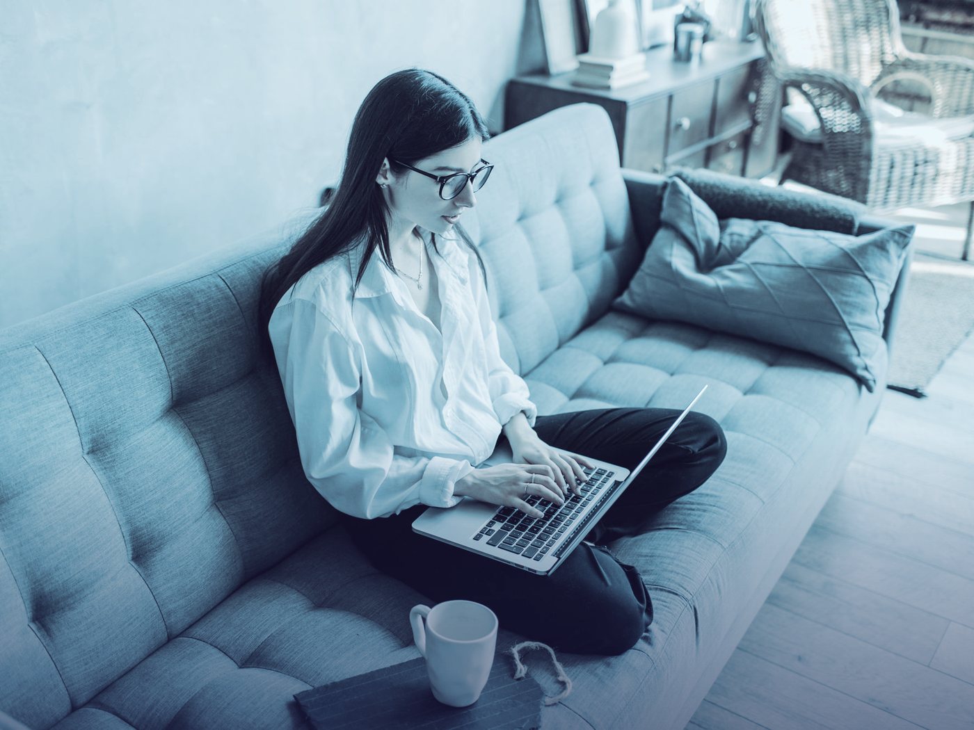 Docente trabajando con su computador en el sillón