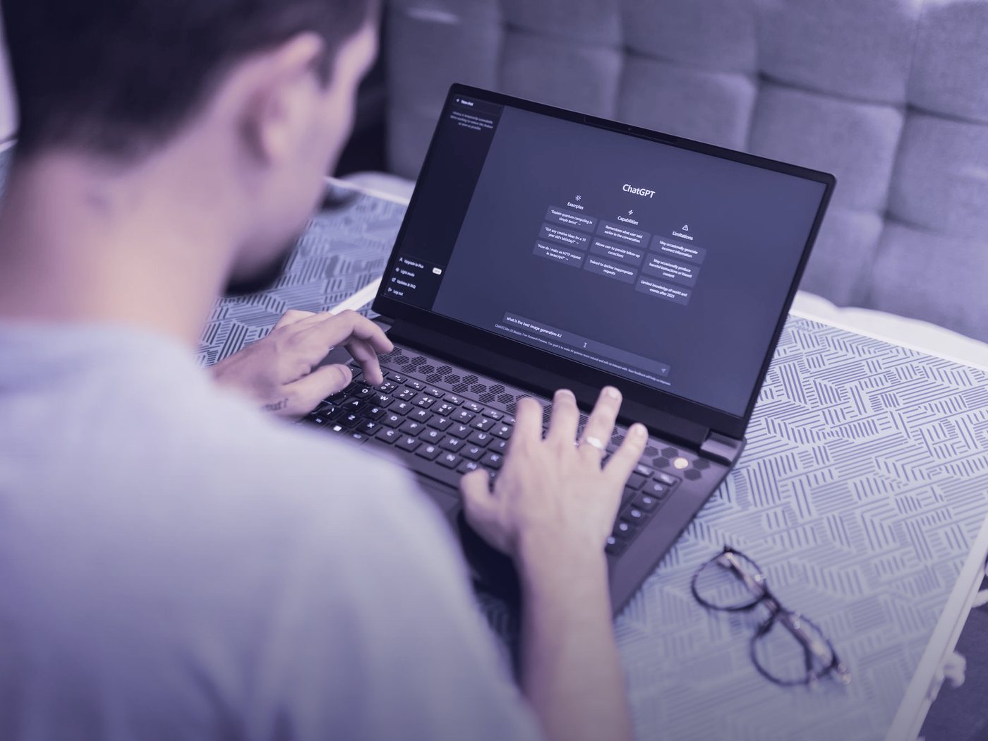Persona escribiendo en un computador con un asistente de IA en pantalla