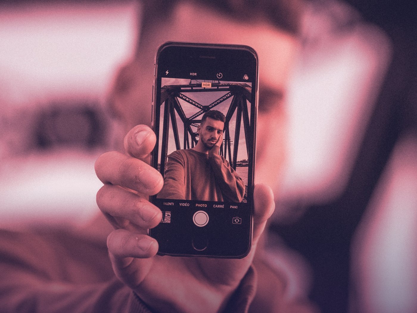 Persona sosteniendo su celular con una selfie en pantalla