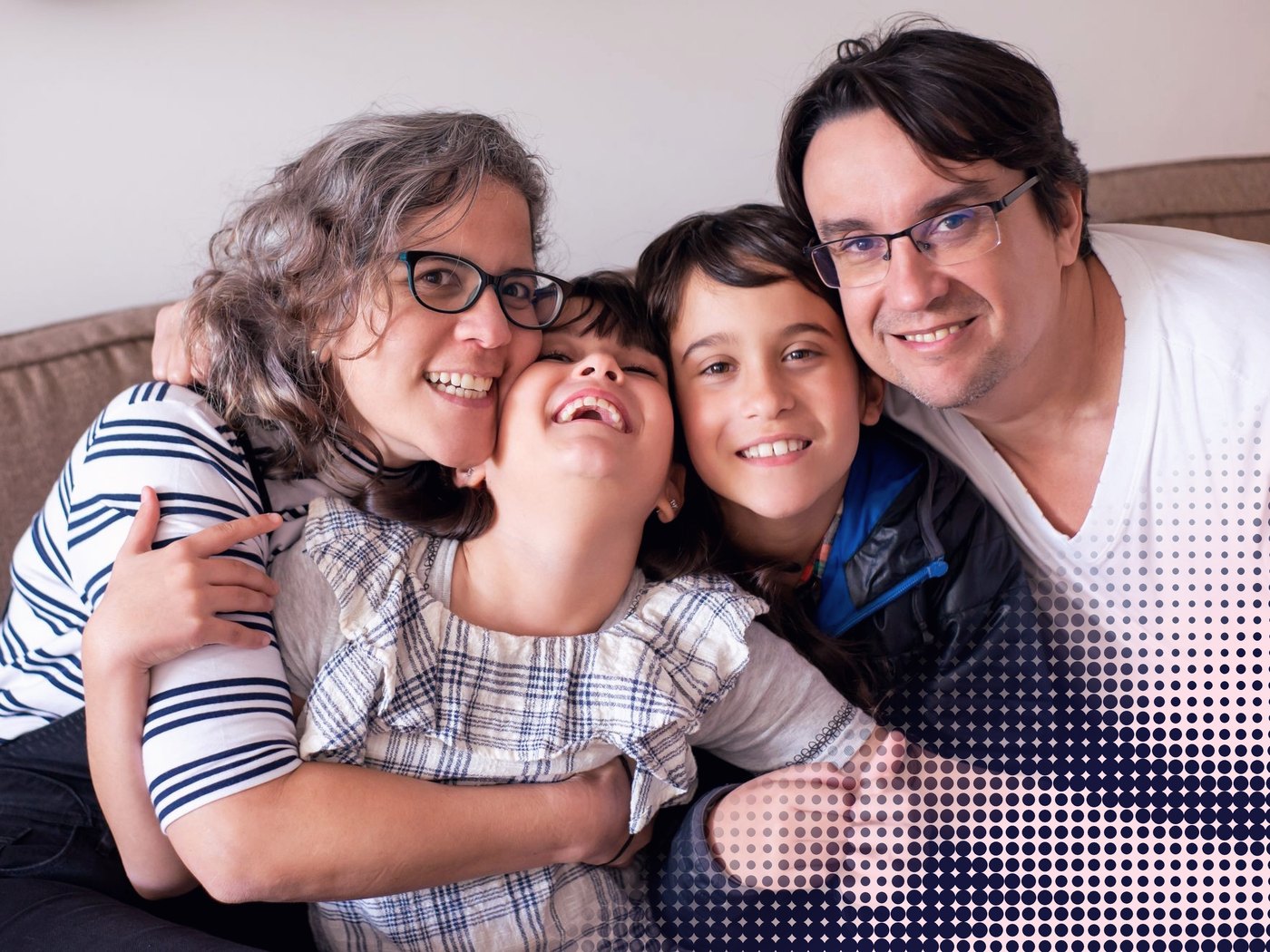 Familia abrazada y sonriendo en el sillón