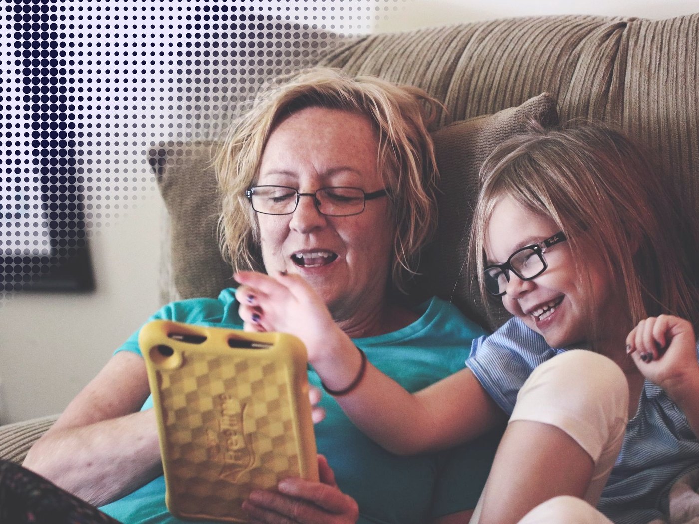 Abuela y nieta riendo mientras usan una tableta