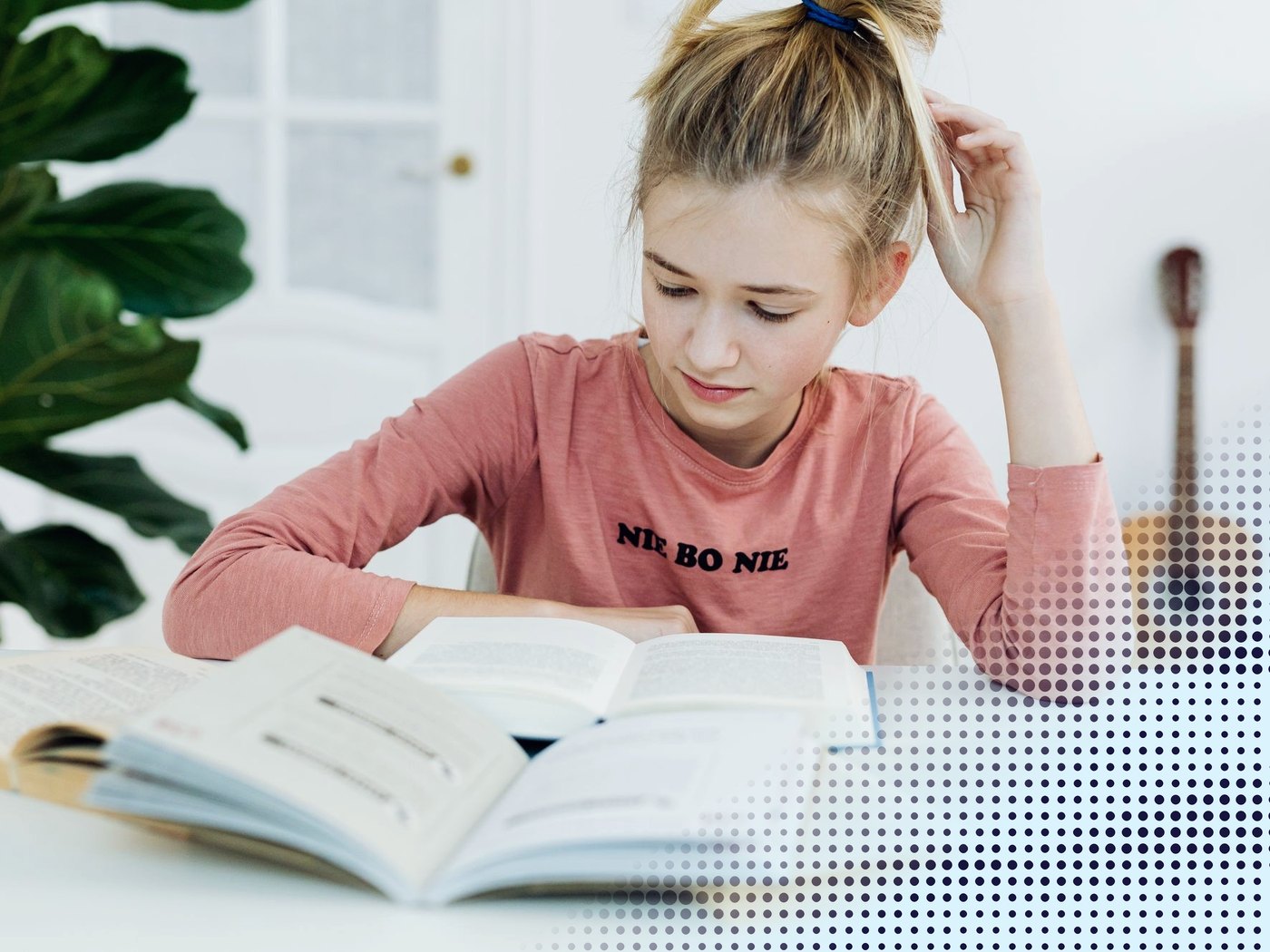 Estudiante leyendo libros en su escritorio