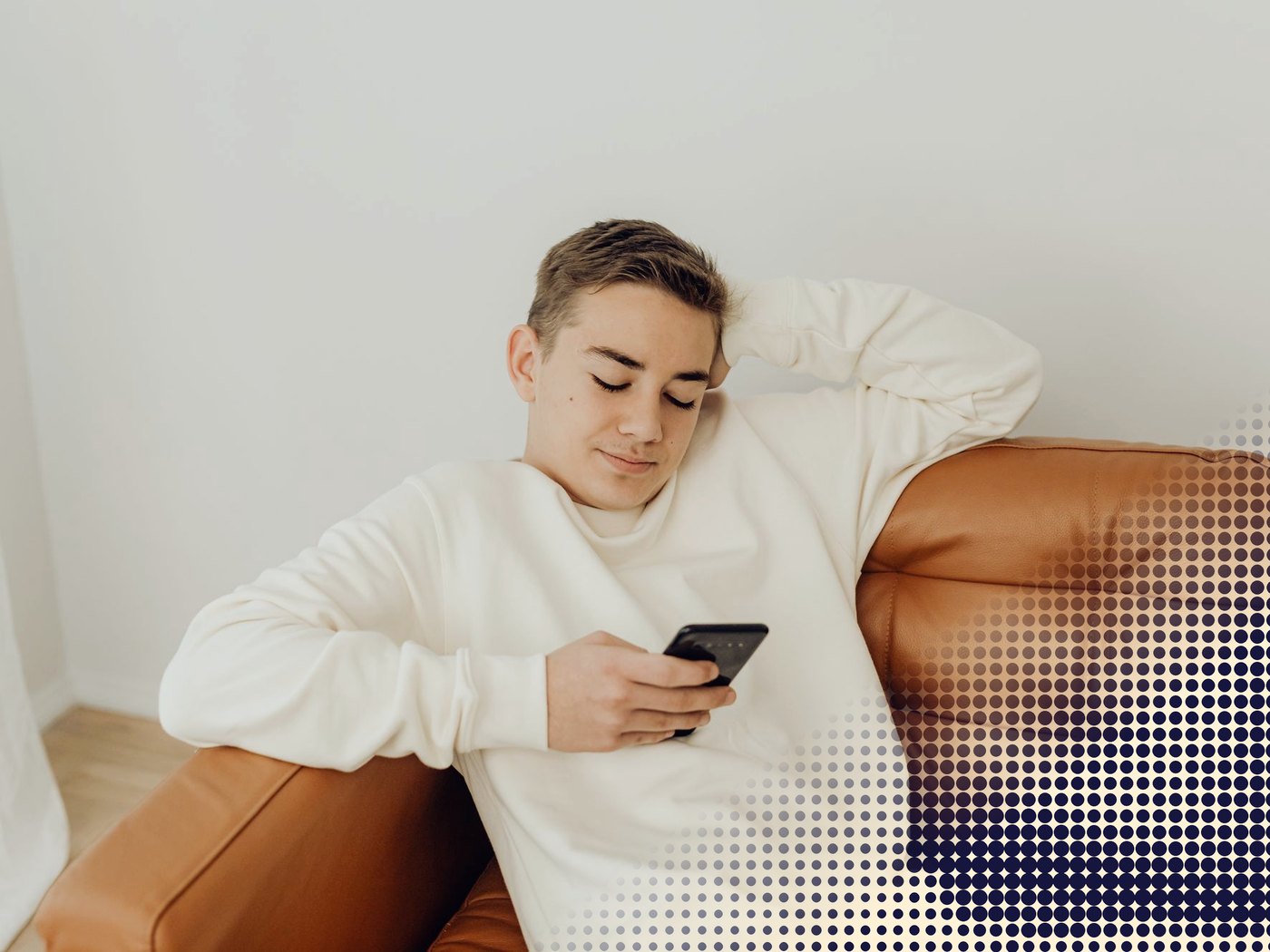 Joven en un sillón revisando su celular