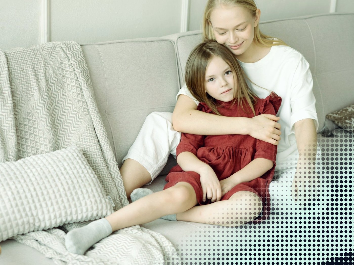 Madre abrazando a su hija en el sillón
