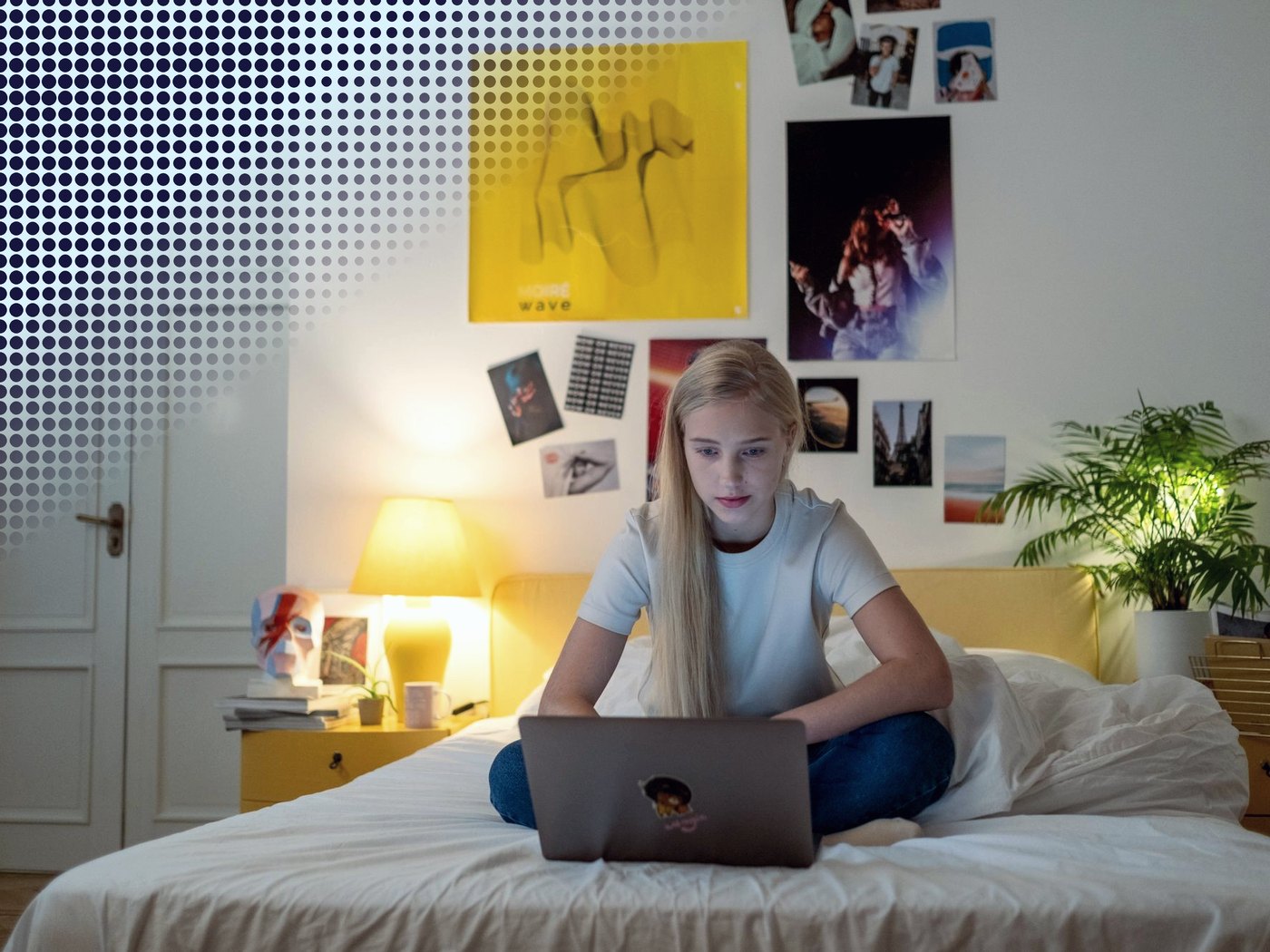 Estudiante trabajando con su computador sentada en la cama