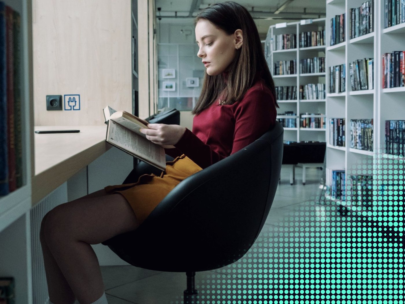 Joven leyendo un libro en una biblioteca
