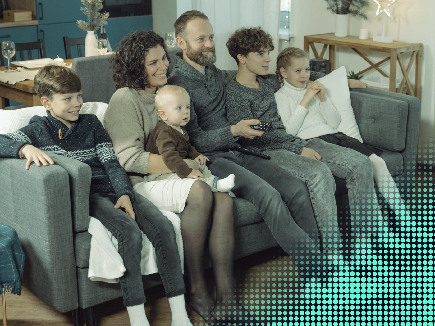 Familia sentada en un sofá viendo televisión juntos