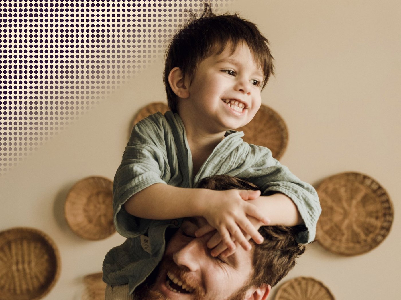 Niño sonriendo sobre los hombros de su papá