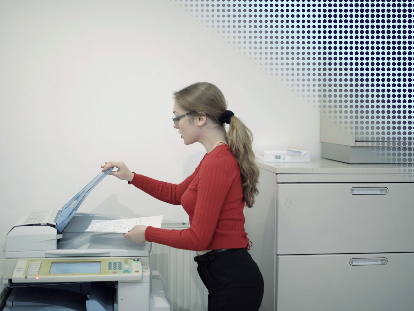 Colaboradora junto a la multifuncional de la oficina