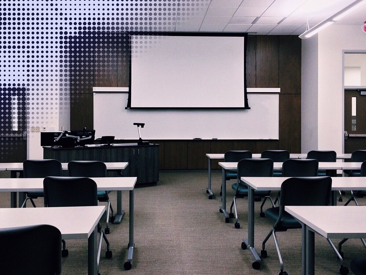 Sala de clases con una pantalla de proyección sobre la pizarra